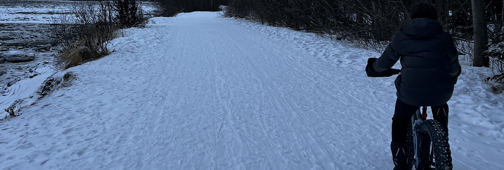 Man riding bike on snowy Anchorage Coastal Trail