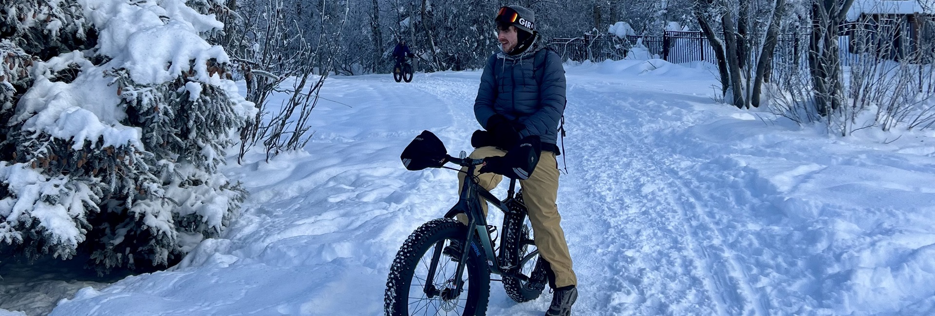 Man stopped on Anchorage Coastal Trail during winter whilte riding a bike.